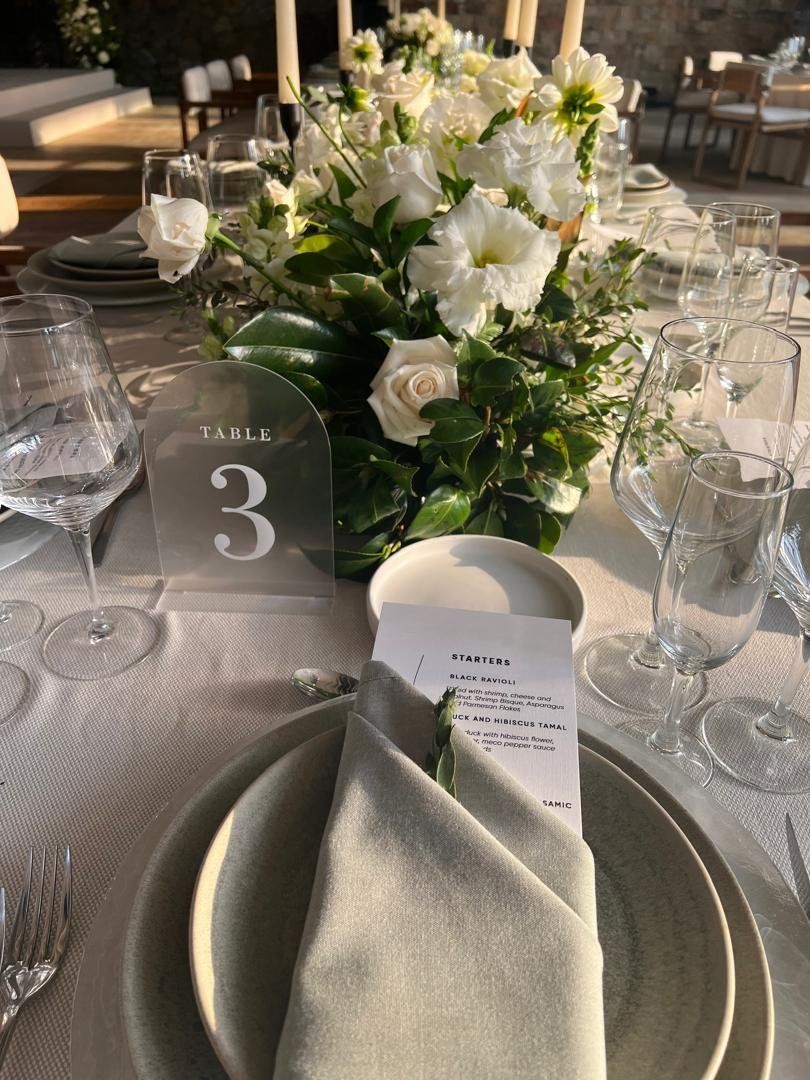 Place setting with sage napkin, menu and table number three